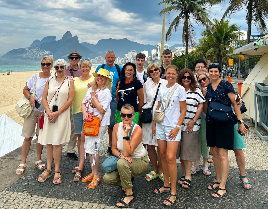 Razem nad oceanem w Rio de Janeiro Grupa CoolTurystek nad oceanem w Rio de Janeiro, z plażą, palmami i górami w tle