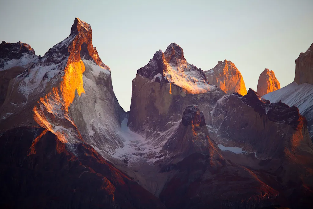 Skaliste szczyty Torres del Paine Jasne skalne ściany Cuernos del Paine z ciemnymi wierzchołkami rozświetlonymi pomarańczowym światłem