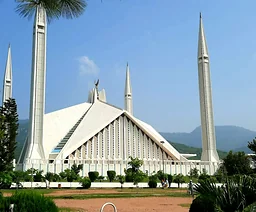 Biały meczet Faisal z minaretami i zielenią na tle wzgórz w Islamabadzie